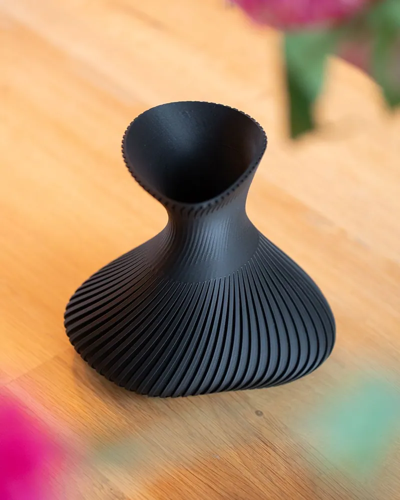 Zwarte Bold Vase met fijne ribbels op een houten tafel