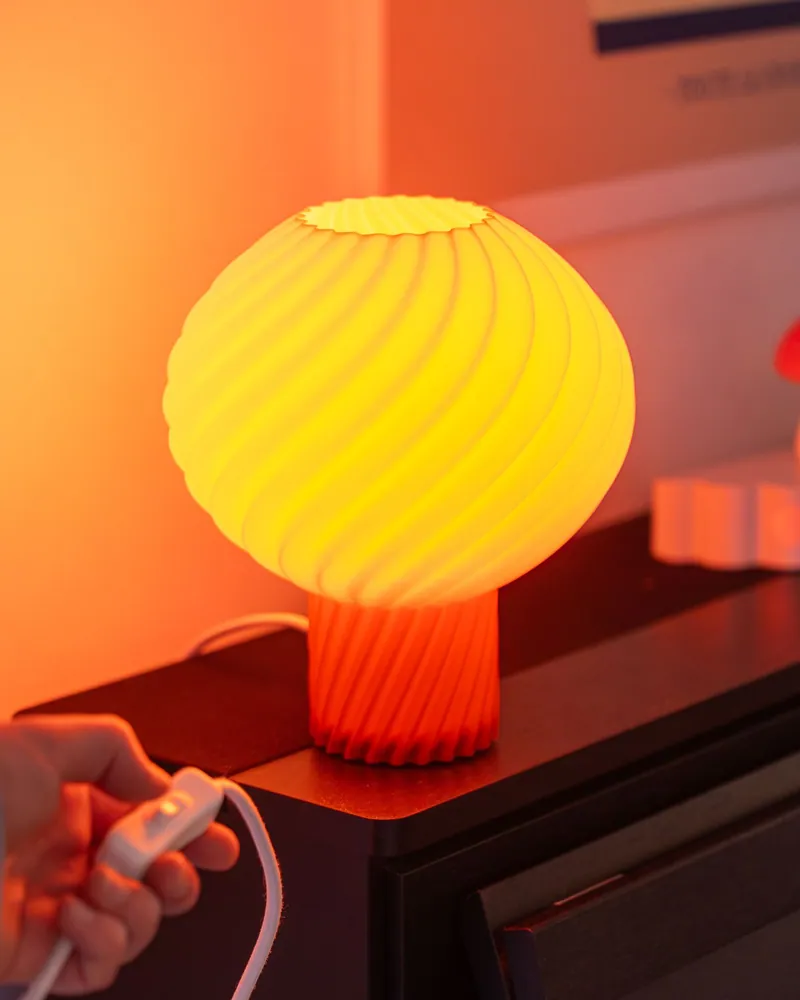 Brandende gele Helio Lamp op een piano, een hand bedient de schakelaar